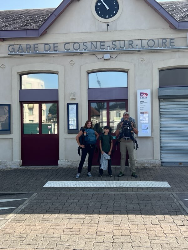 Famille de 3 personnes en sacs à dos devant la gare de Cosne sur Loire prête à partir en tour du monde.