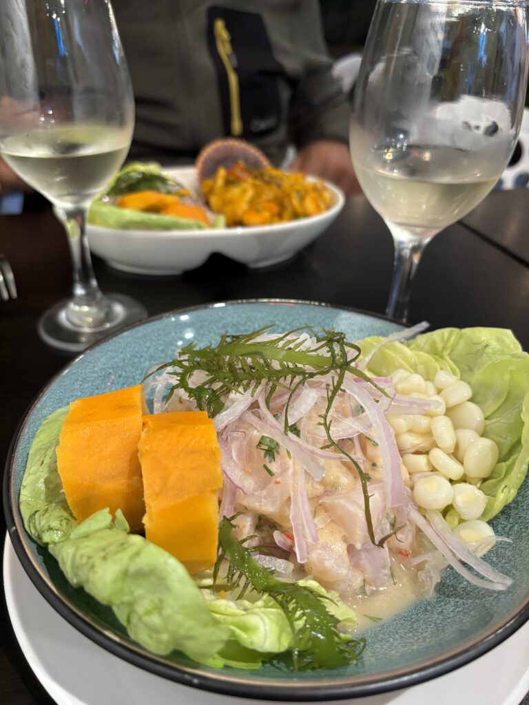 Assiette de ceviche péruvien avec morceaux de poisson cru marinés au citron vert, accompagnés de maïs et patate douce.
