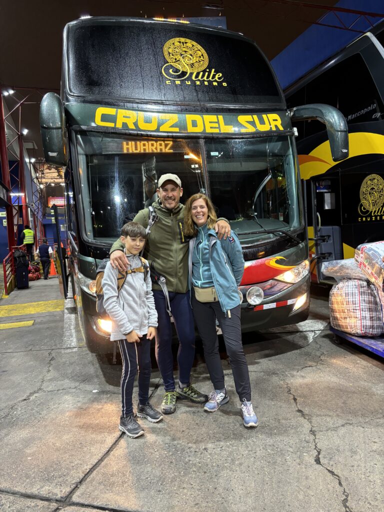 Une famille devant un bus Cruz del Sur prêt à partir en voyage de nuit vers le nord du Pérou.