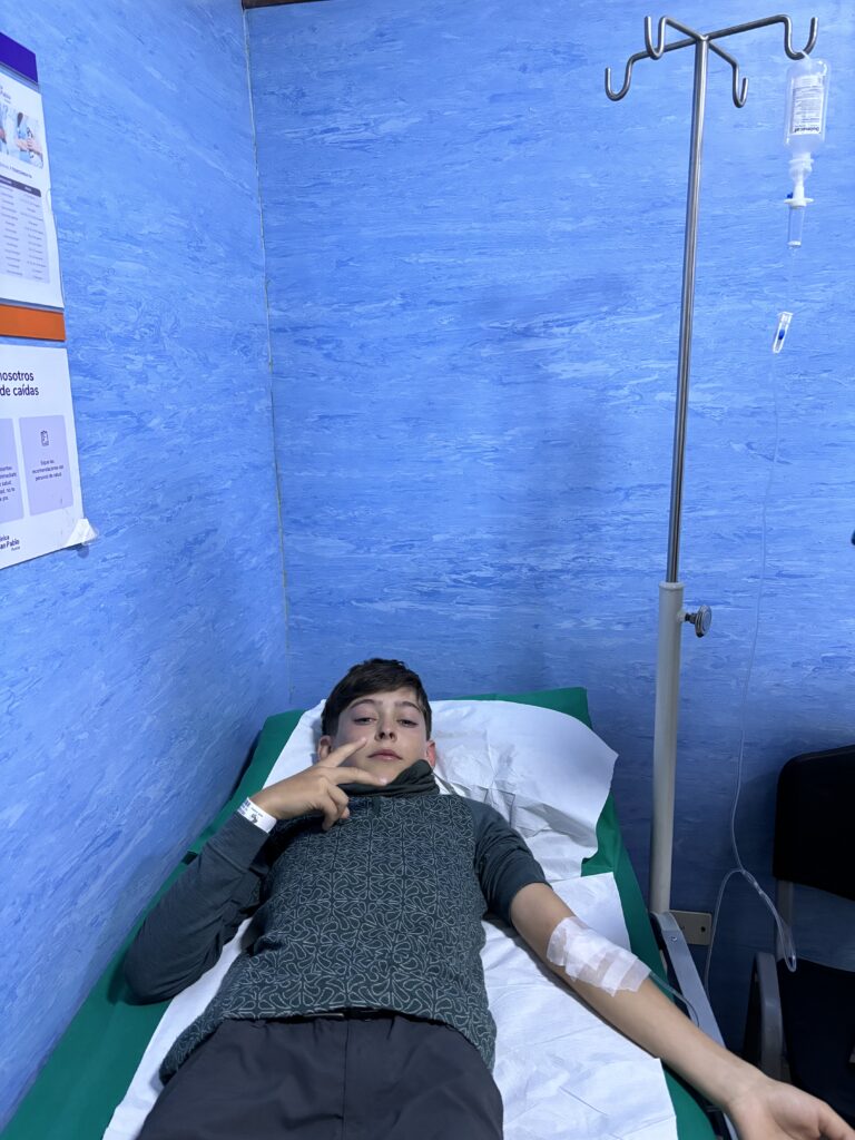 Un jeune garçon, Célian, allongé aux urgences au Pérou, sous perfusion.