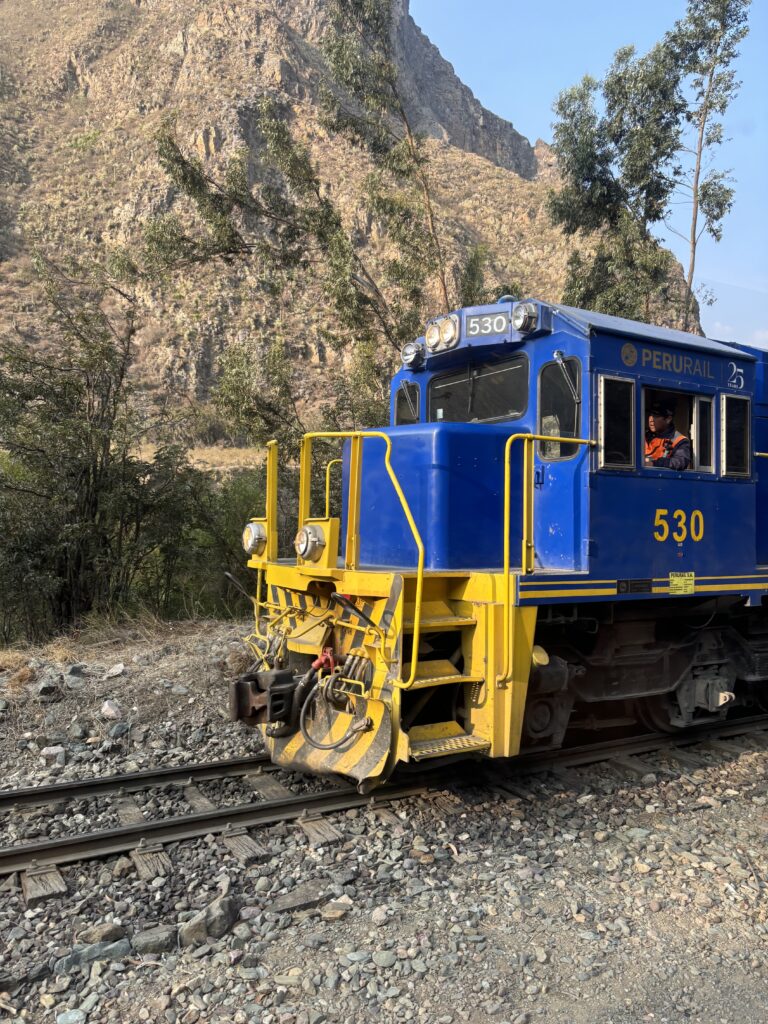 Locomotive bleue et jaune en gare, train touristique vers le Machu Picchu