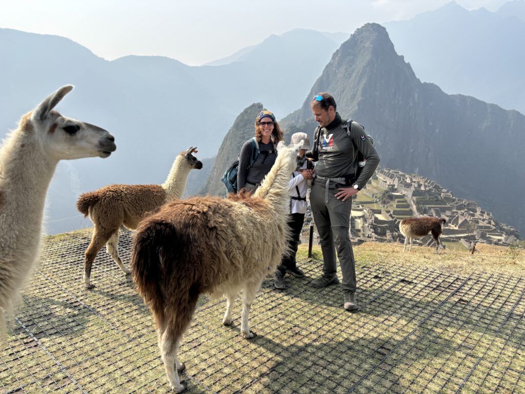 Notre famille entourée de lamas avec en fond le Machu Picchu