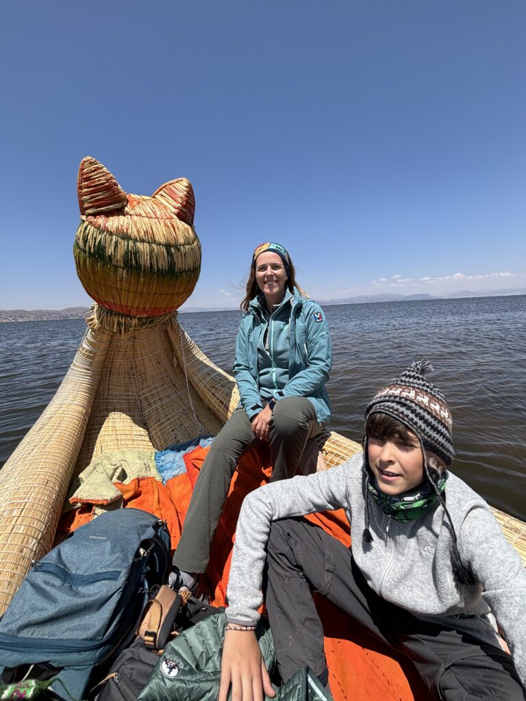 Une mère et son fils assis sur une embarcation traditionnelle en roseaux sur le lac Titicaca.