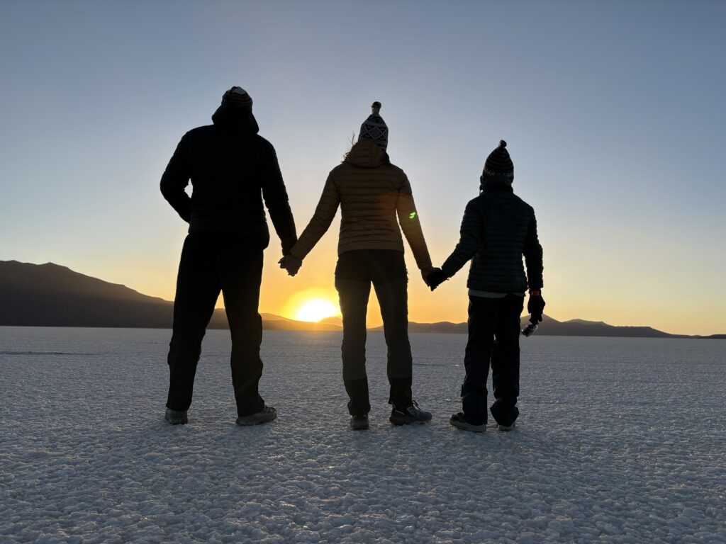 Famille en voyage, main dans la main au coucher de soleil lors de notre tour du monde