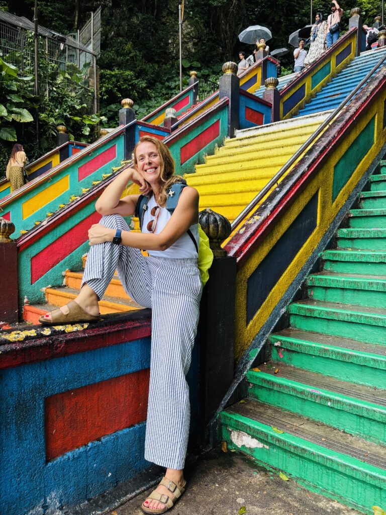 Armelle en voyage, assise sur des marches colorées lors du tour du monde