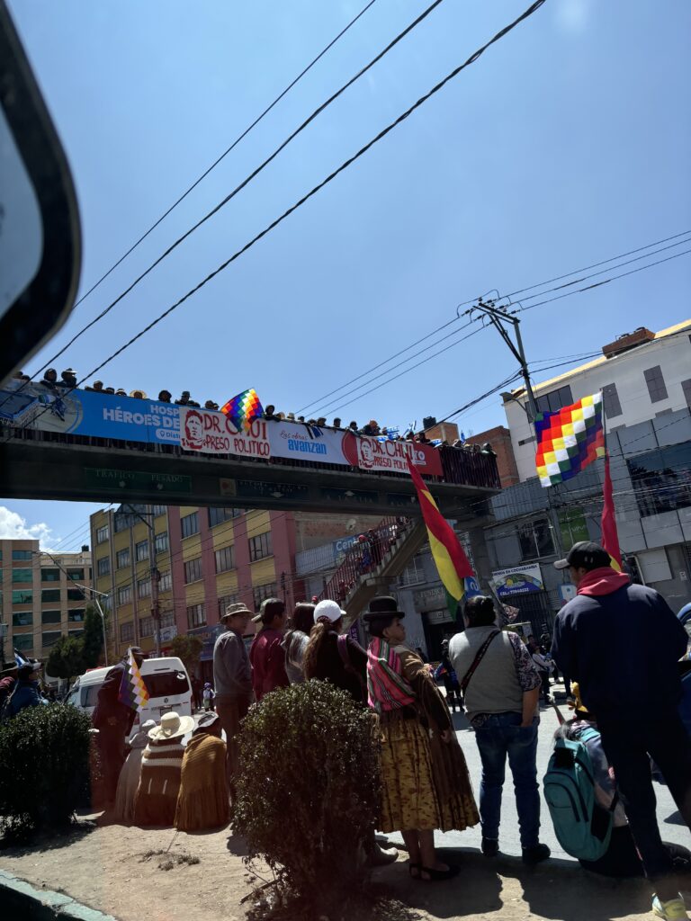 Manifestation colorée à La Paz, Bolivie, avec drapeaux andins et foule dans les rues.