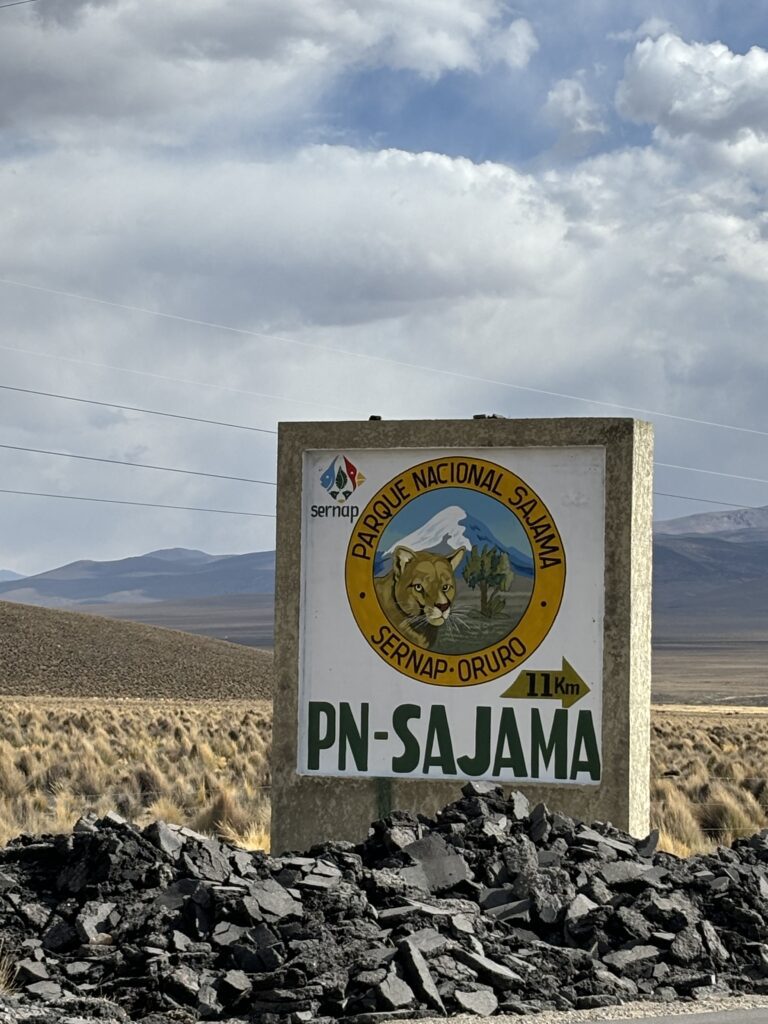 Panneau d’entrée du Parc national Sajama en Bolivie, entouré de paysages andins.
