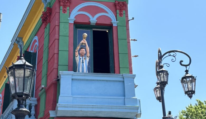 Façade colorée du quartier de La Boca à Buenos Aires, avec une statue de Maradona saluant depuis un balcon du Caminito.